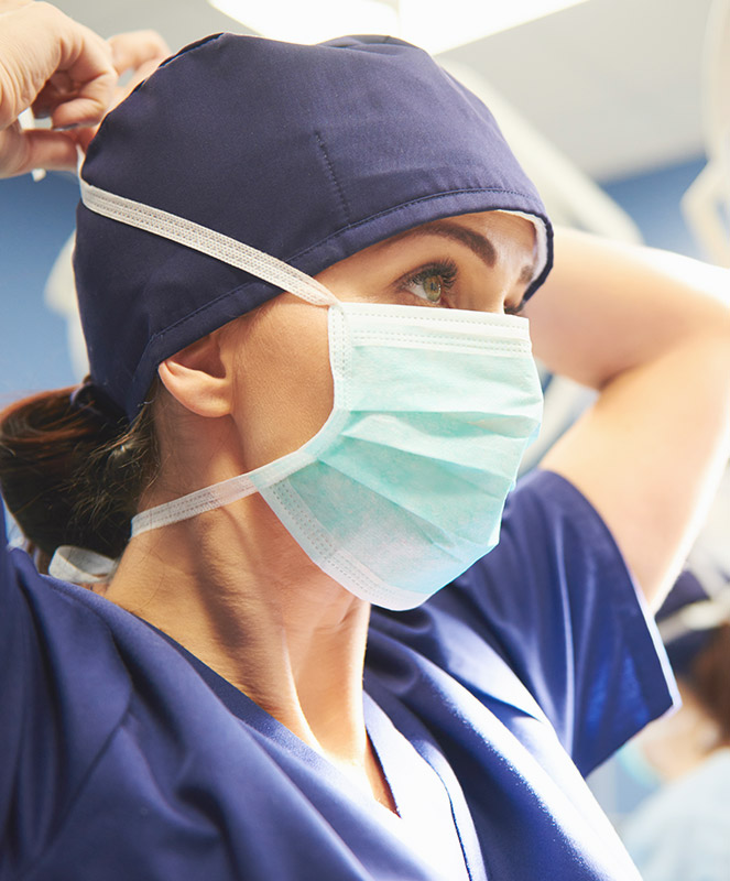 Woman putting on medical protective equipment
